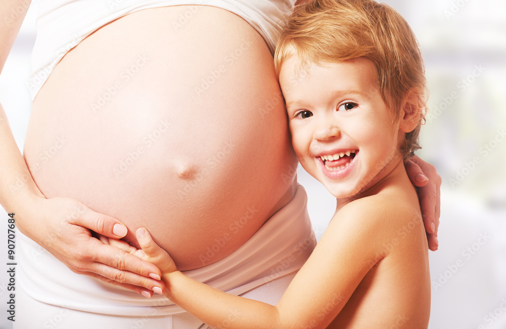 Happy family. Child hugs belly of pregnant mother