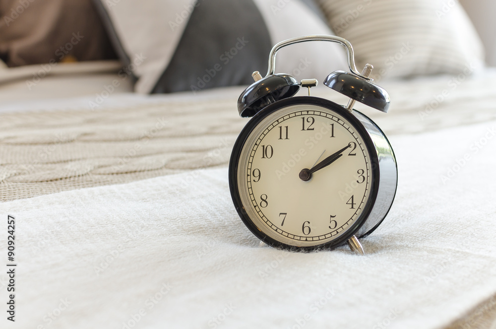 modern black alarm clock on bed