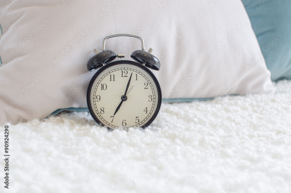 modern black alarm clock on bed