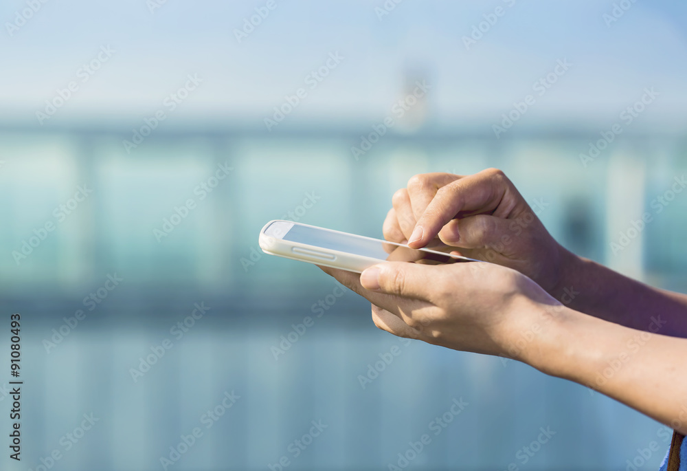 Person holding a smartphone on a city backdrop