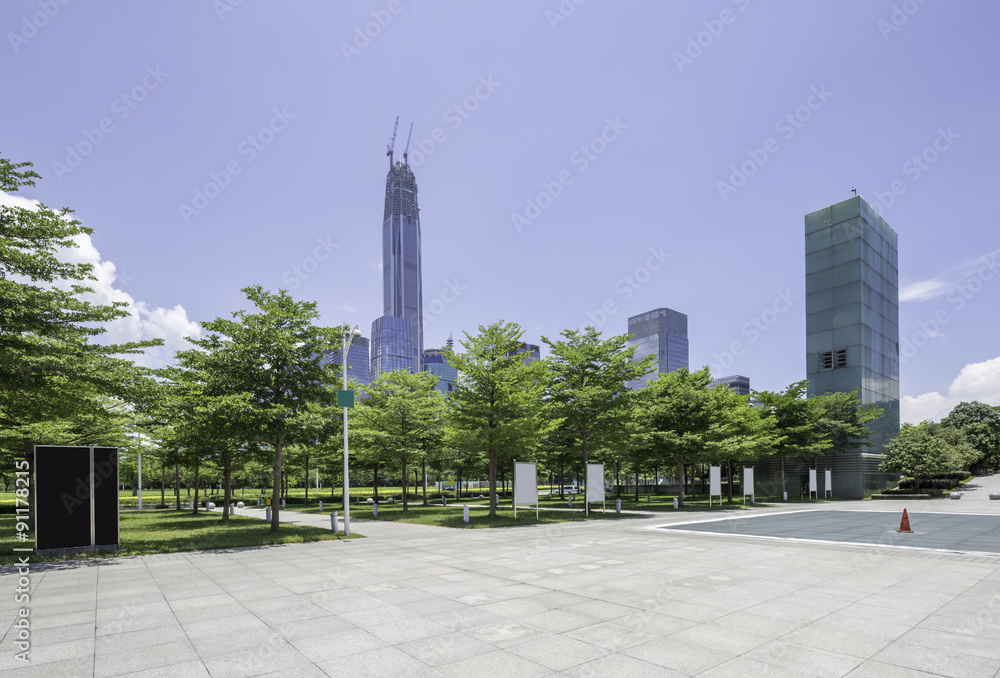 city square with treelawn is close to skyscraper