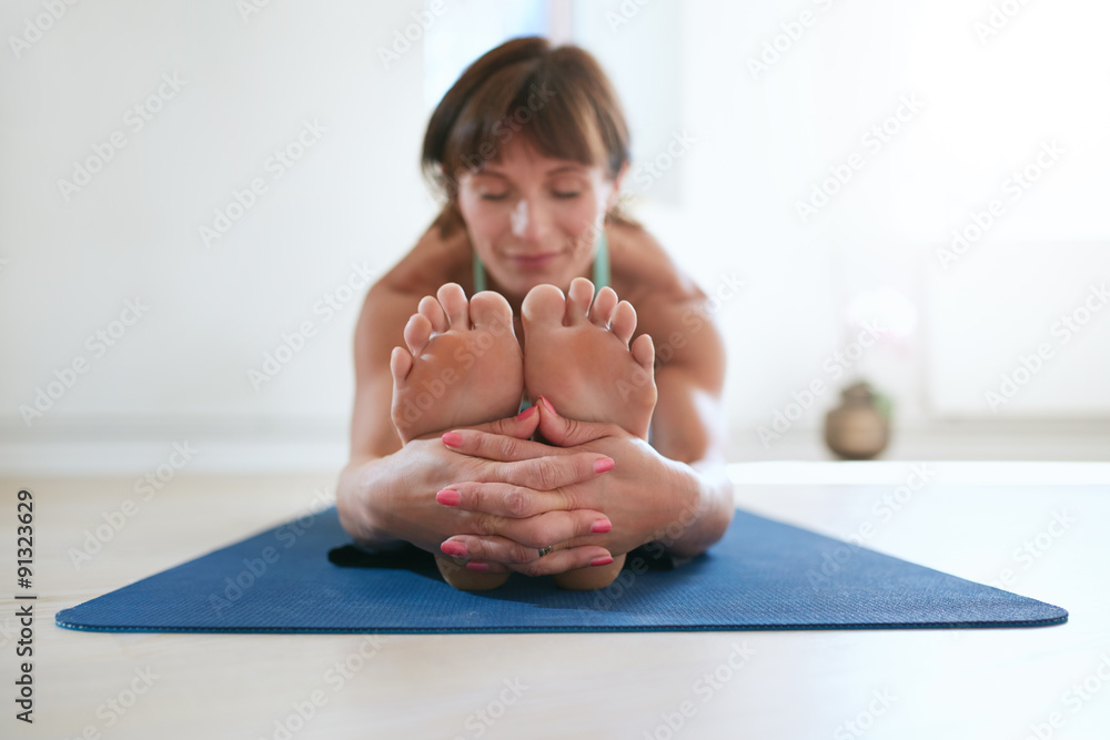 Woman practicing Paschimottanasana yoga.