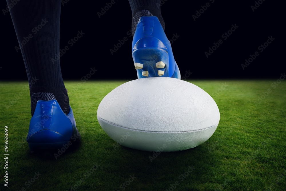 Composite image of rugby player posing feet on the ball