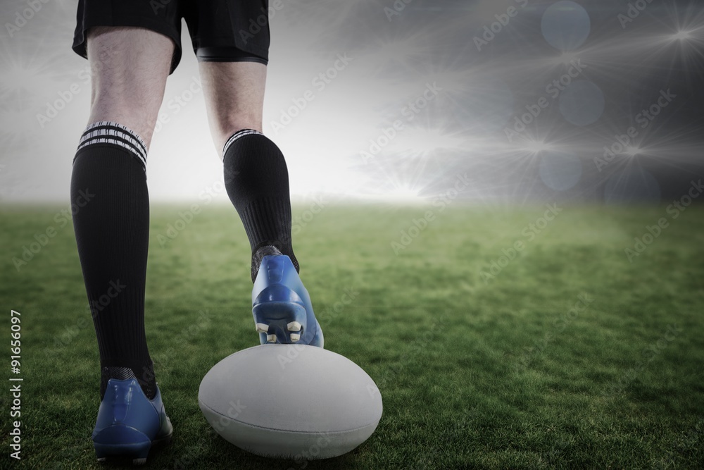 Composite image of rugby player posing feet on the ball