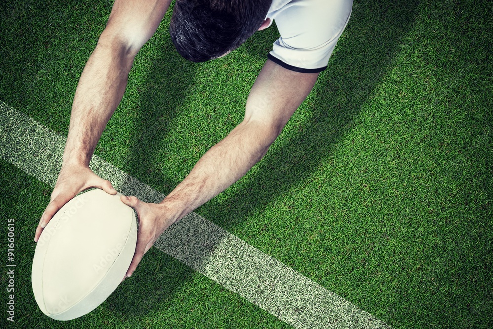 Composite image of high angle view of man holding rugby ball