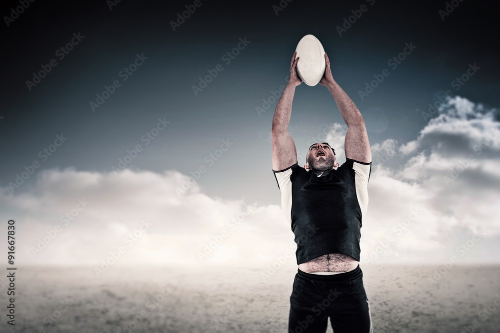 Composite image of rugby player catching the ball