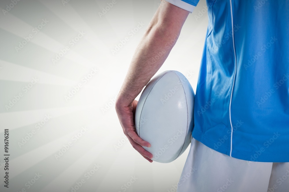 Composite image of serious rugby player with arms crossed