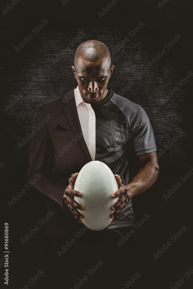 Composite image of thoughtful athlete looking at rugby ball