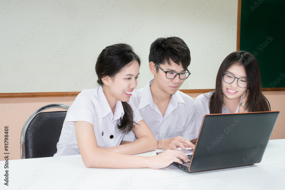 一群穿着制服的亚洲学生通过c版笔记本电脑进行电子学习