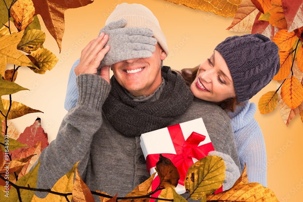 Composite image of woman surprising husband with gift