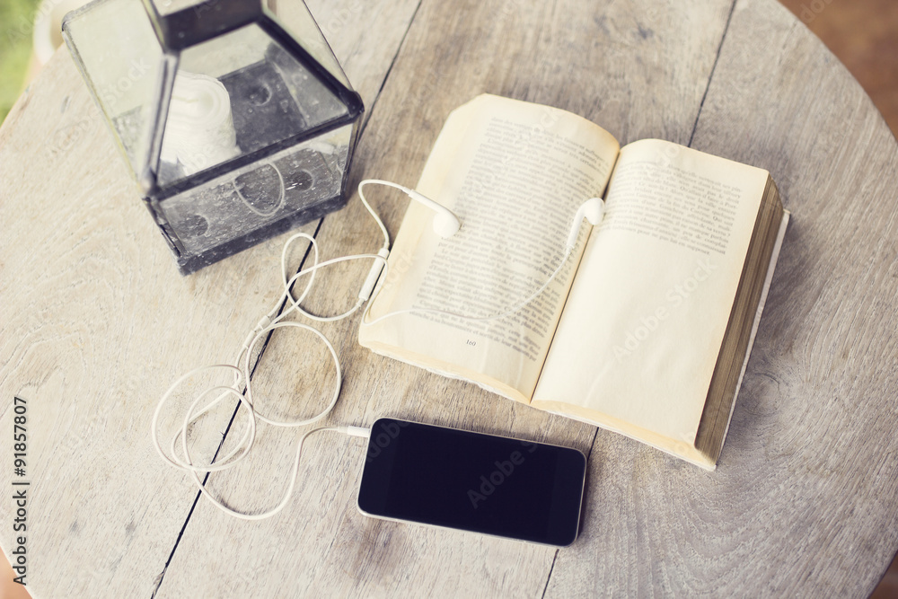 Cell phone and open book on a wooden table