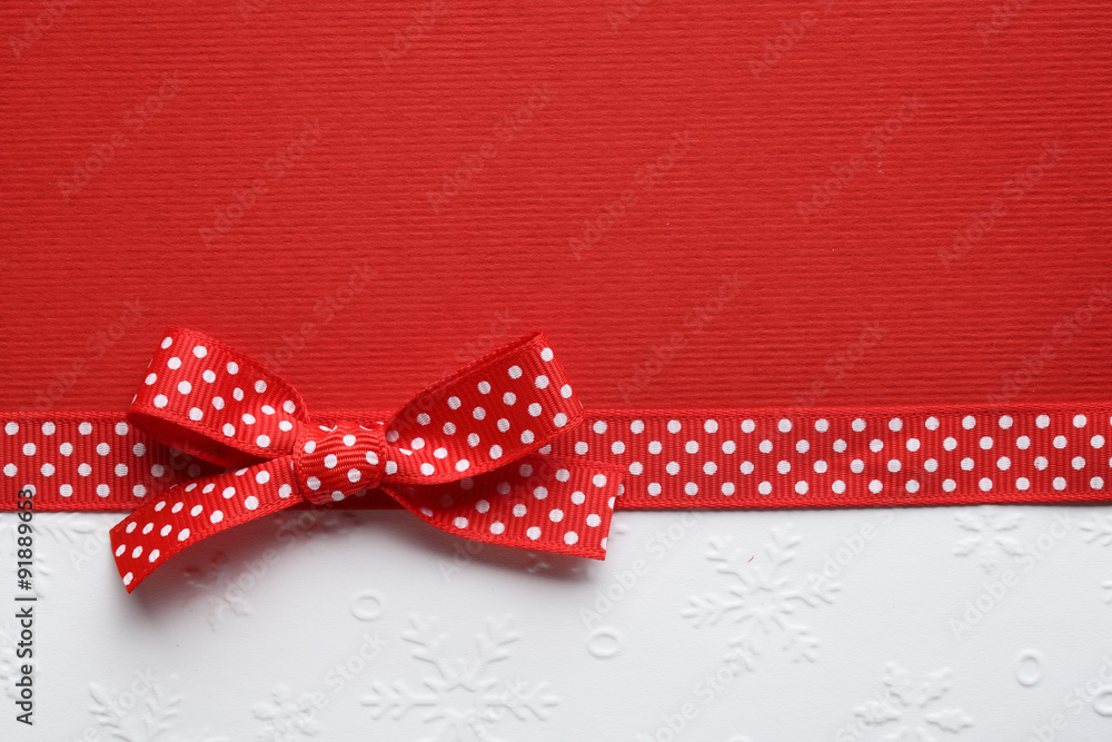 Red ribbon bow on paper