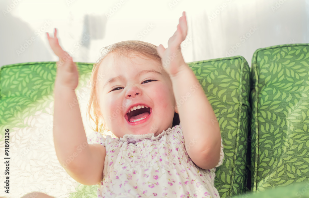 Toddler girl smiling and clapping her hands