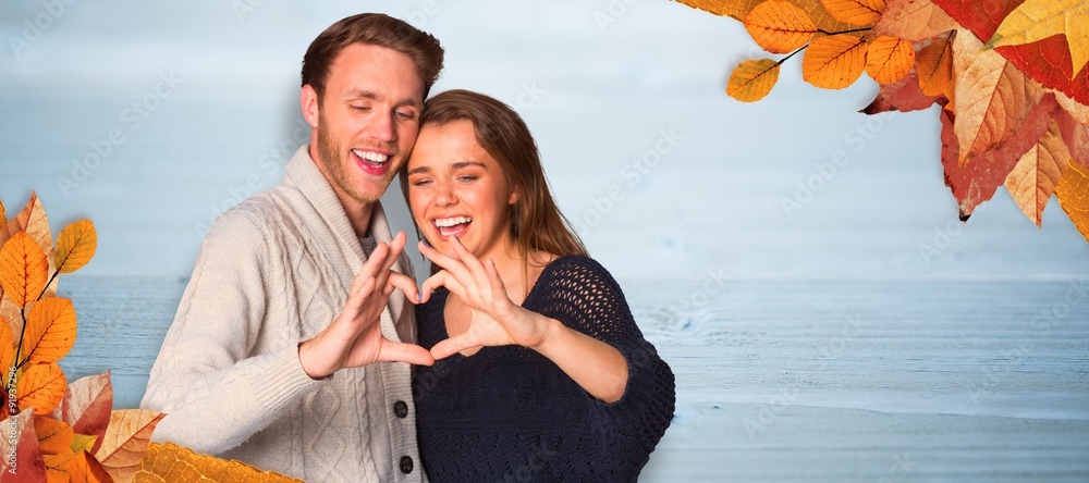 Composite image of happy couple forming heart with hands