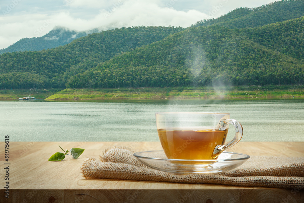 木桌和沼泽背景上的粗麻布茶杯