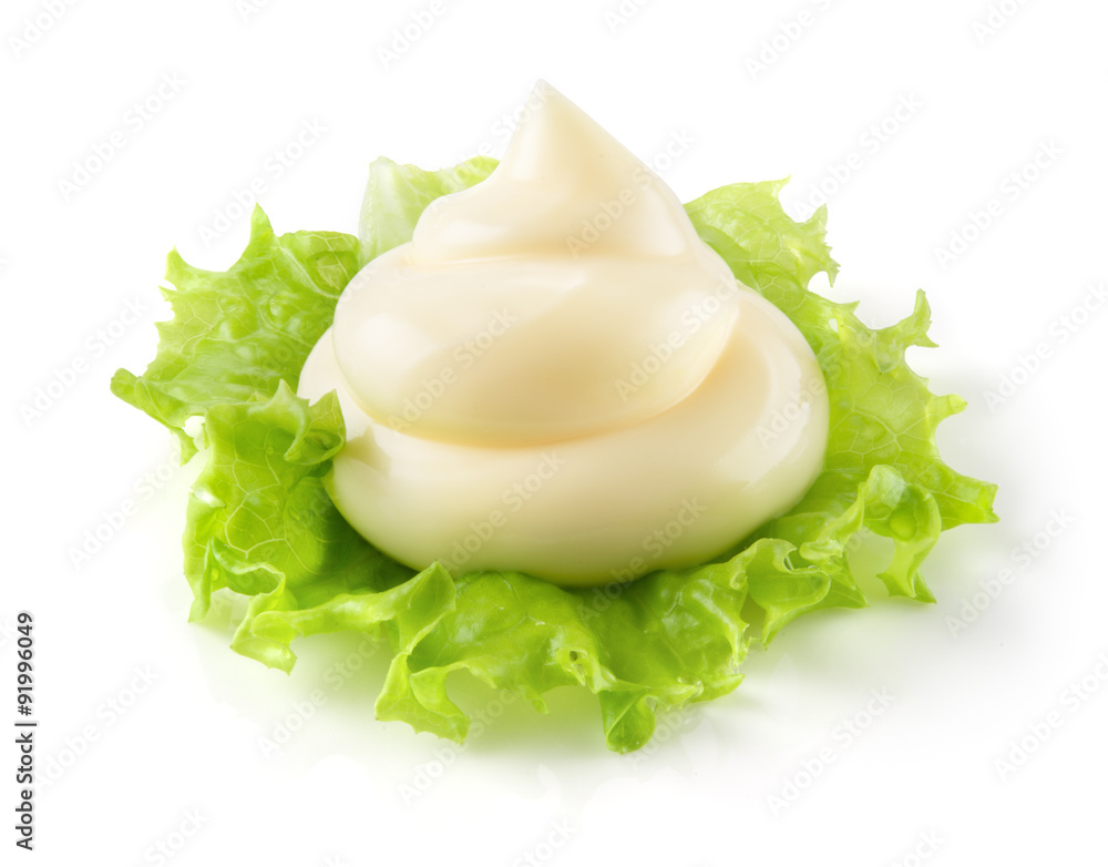 Handful of mayonnaise. Swirl on green leaf. Clipping path.