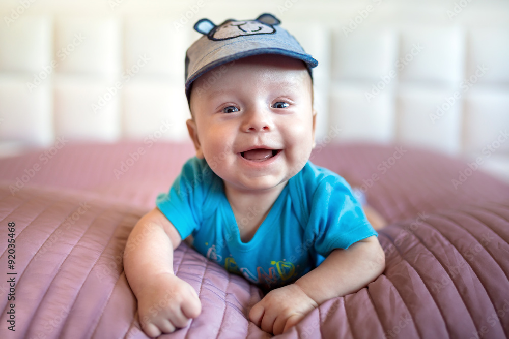 Smiling baby boy lying in bed