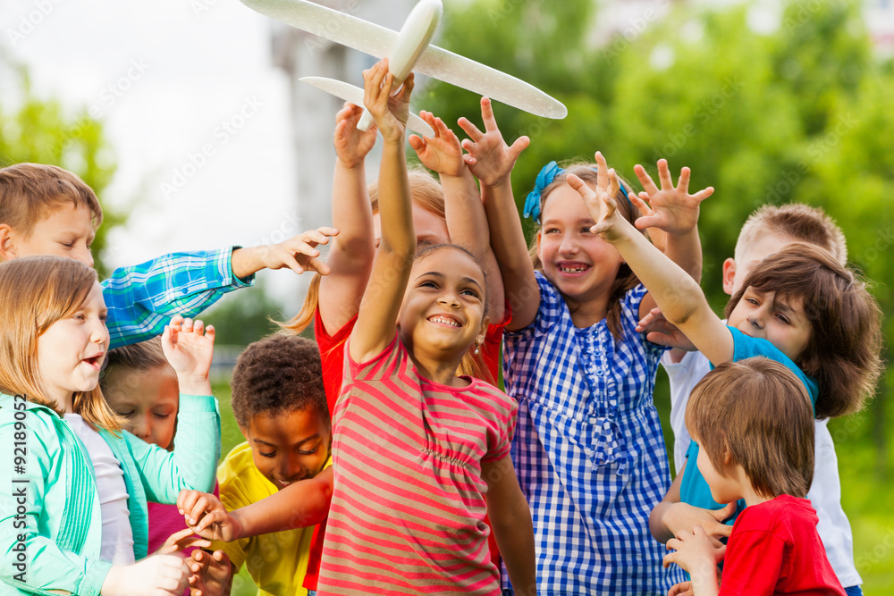 Close-up view of kids reaching after airplane toy