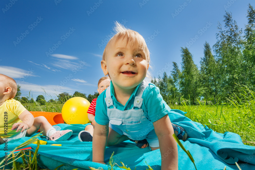 Close-up view of toddlers sitting on blanket