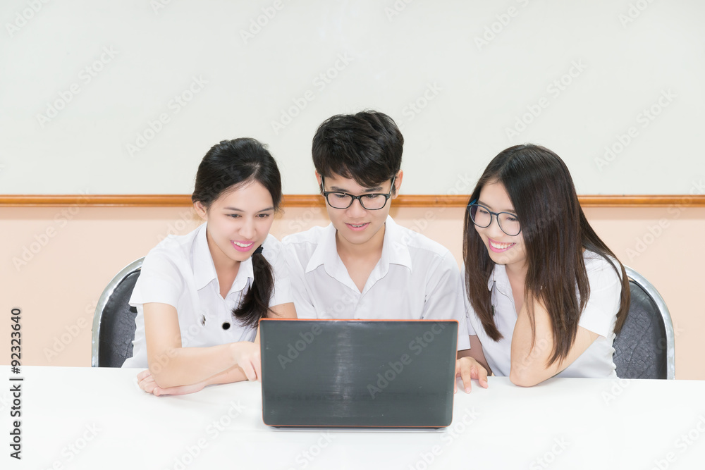 Group of Asian student in uniform E-learning through Laptop in c