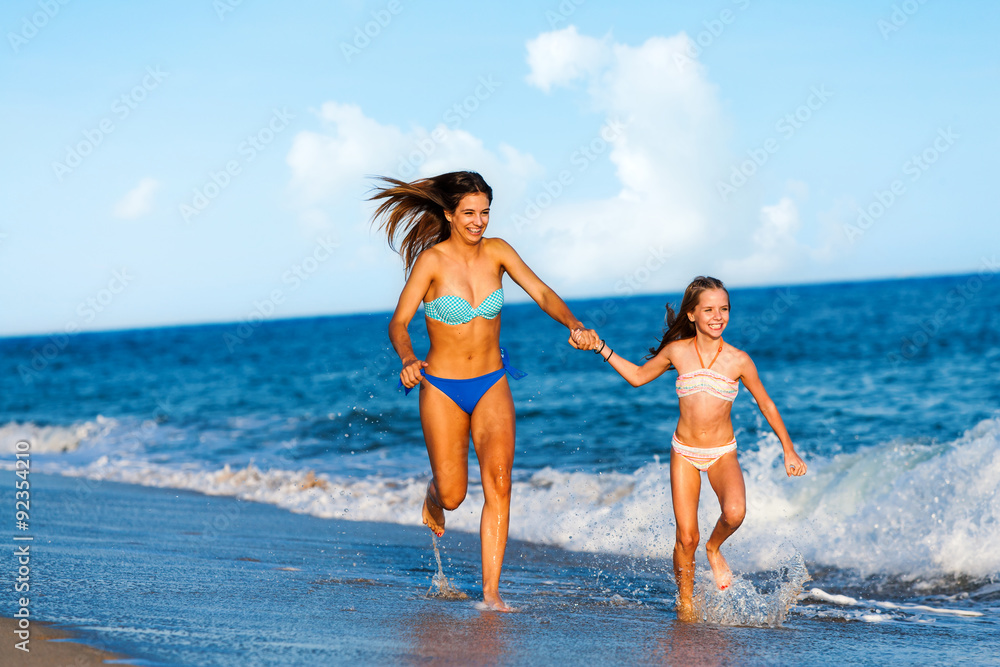 Young women having fun along beach.