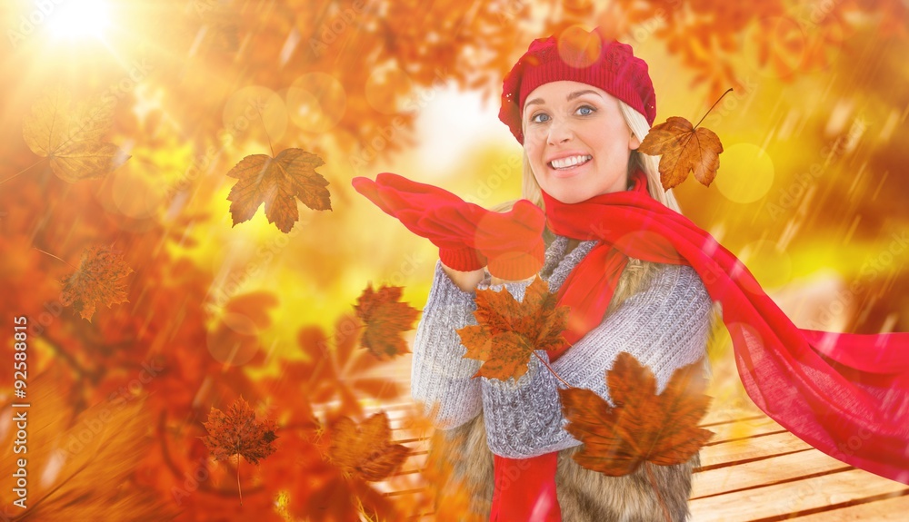 Composite image of blonde in winter clothes with hands out