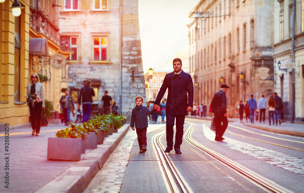 fashionable father and son walking in old city street