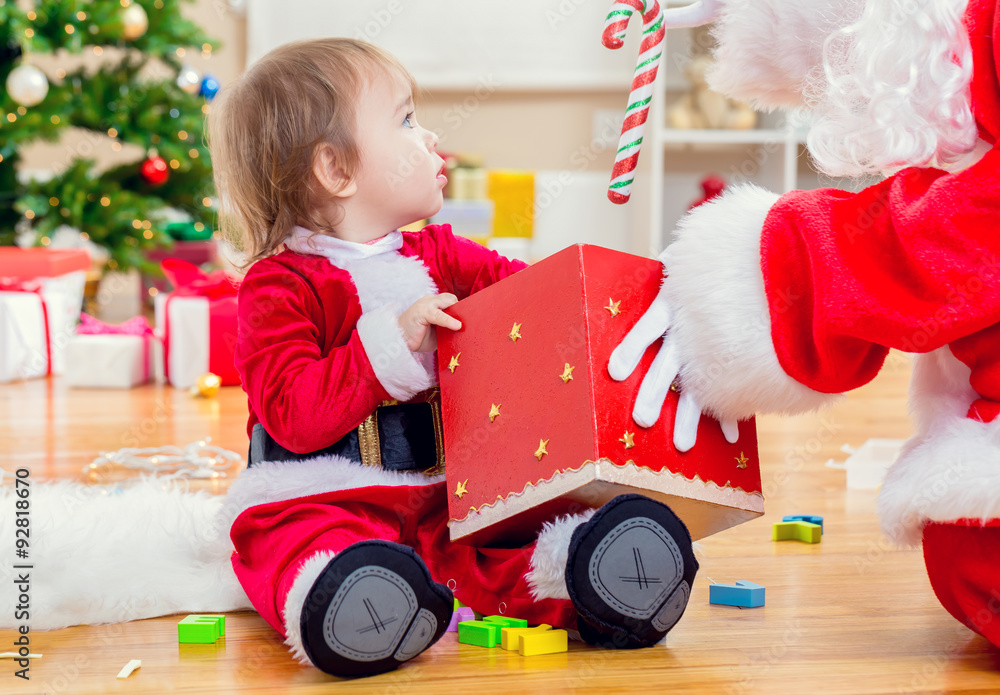 Little toddler girl receiving a gift from Santa Claus