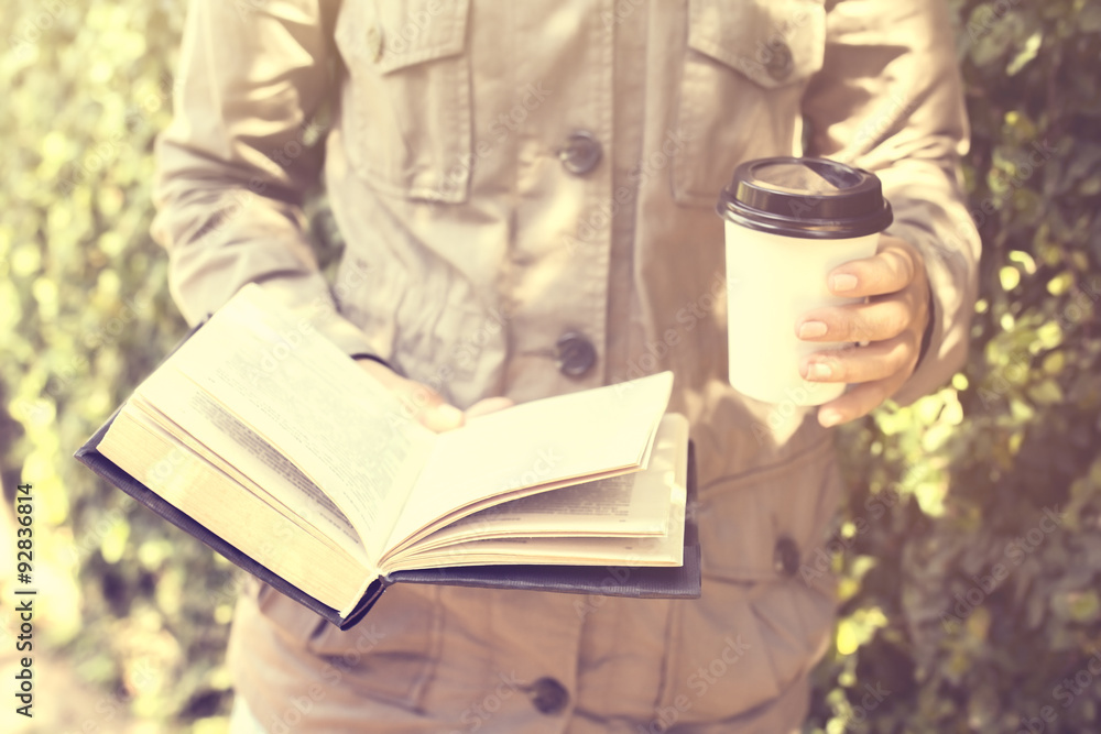 Girl with cup of coffee and a book, vintage photo effect