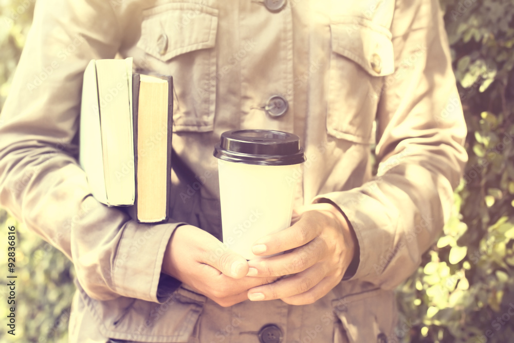 Schoolgirl is keeping books and cup of coffee