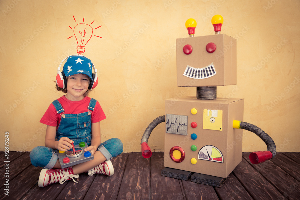 Happy kid playing with toy robot