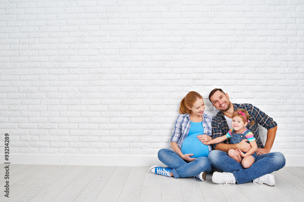 Happy family father and pregnant mother and child daughter near