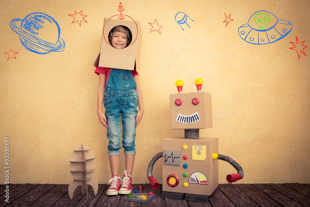 Happy kid playing with toy robot