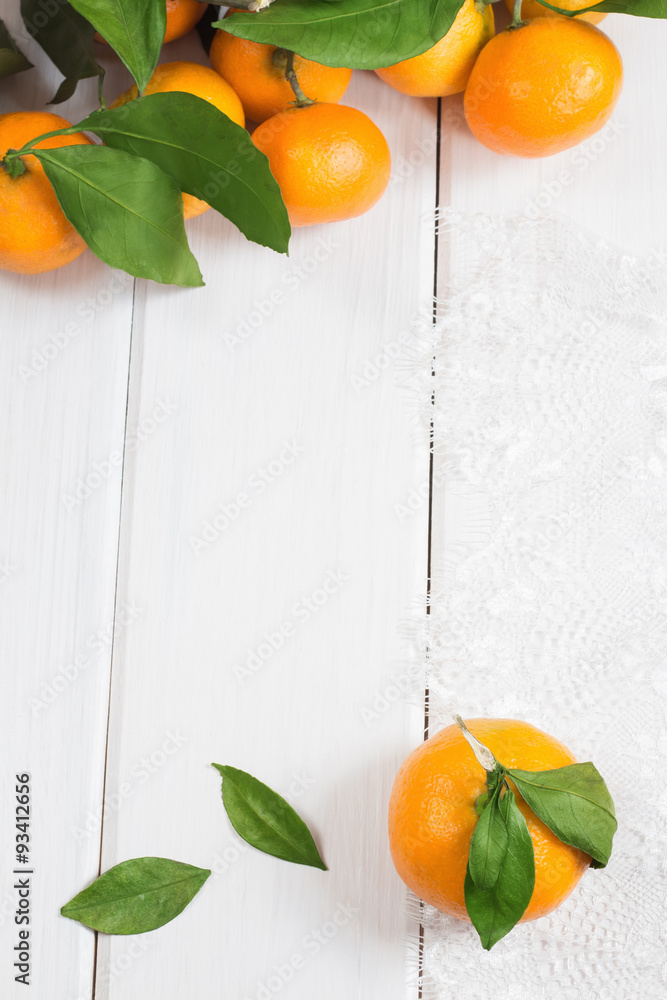 Ripe tangerines on white wooden background