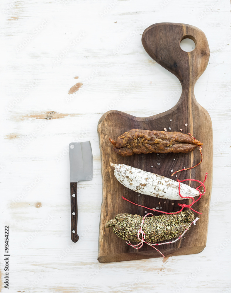 French alsacian smoked salamis on rustic walnut wooden chopping