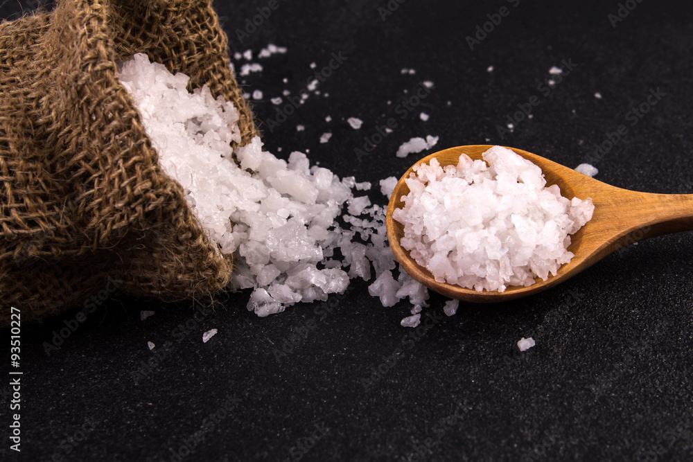 salt crystals on black stone plate background , selective focus