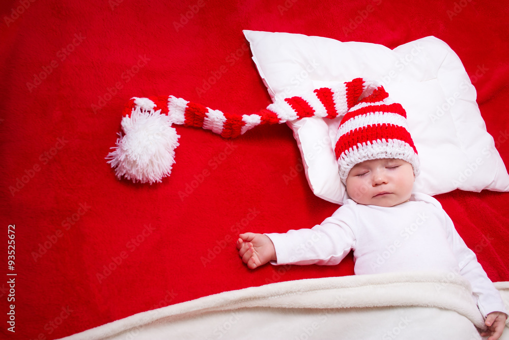 Sleepy baby on red blanket