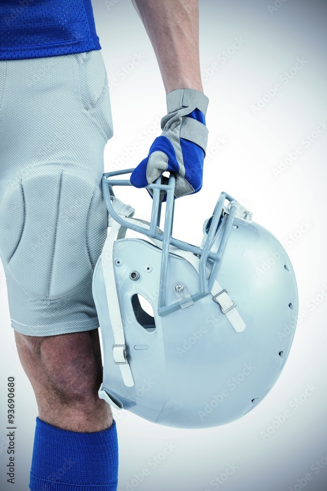 Close-up of American football player holding helmet on white background