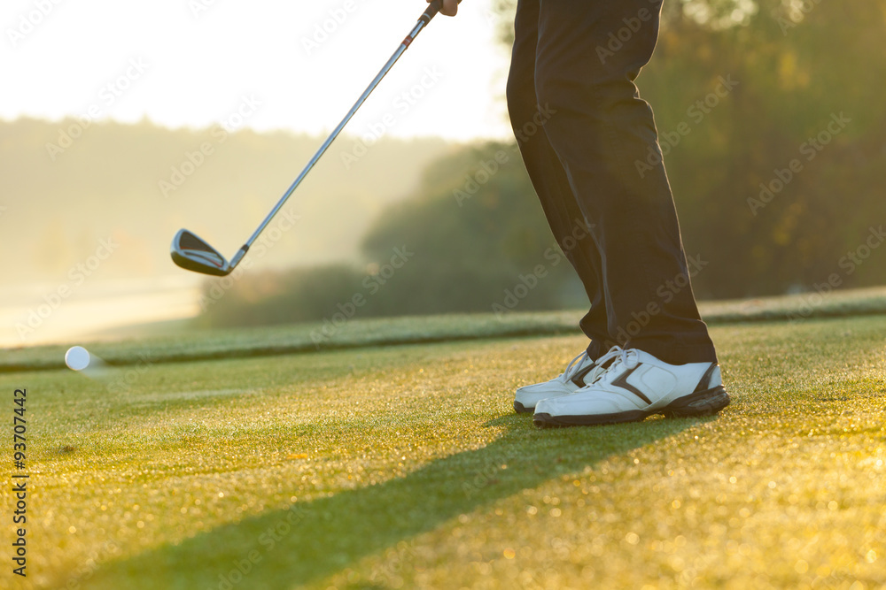 Close-up of man playing golf on green course