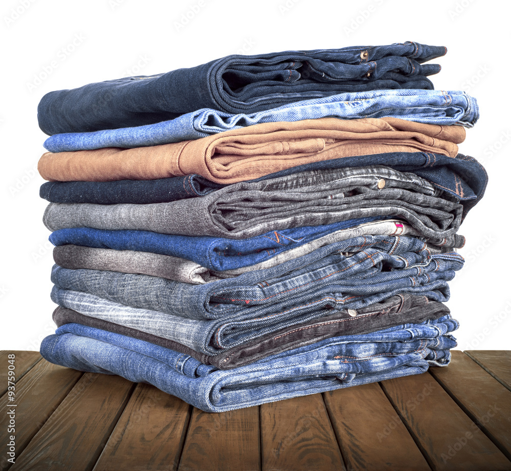 Stack of  jeans lying on a wooden table