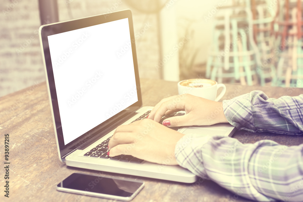 Girl and blank screen of laptop with smartphone and coffee on a