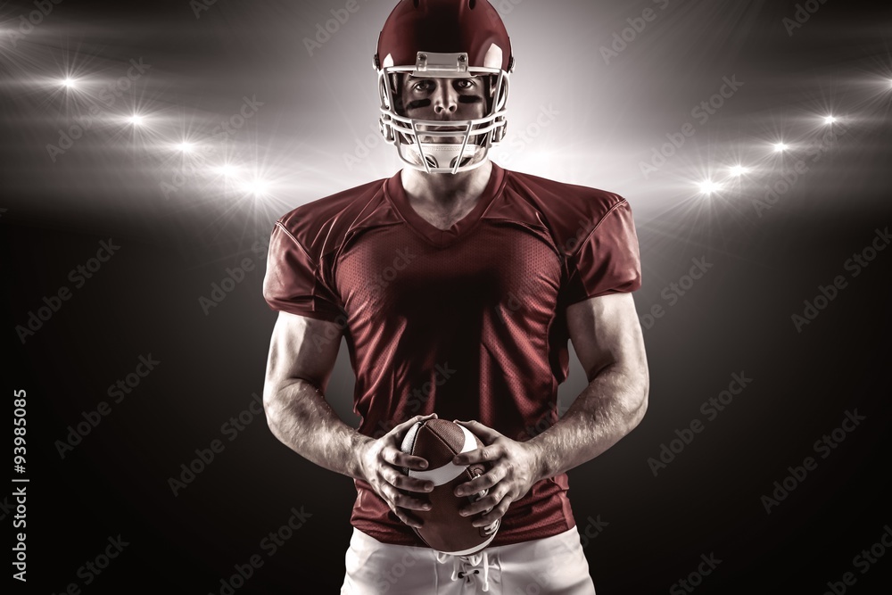 Composite image of american football player holding ball