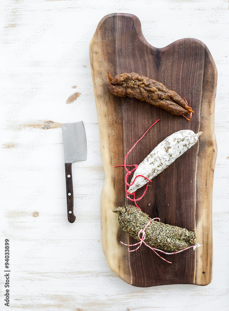 French alsacian smoked salamis on rustic walnut wooden chopping