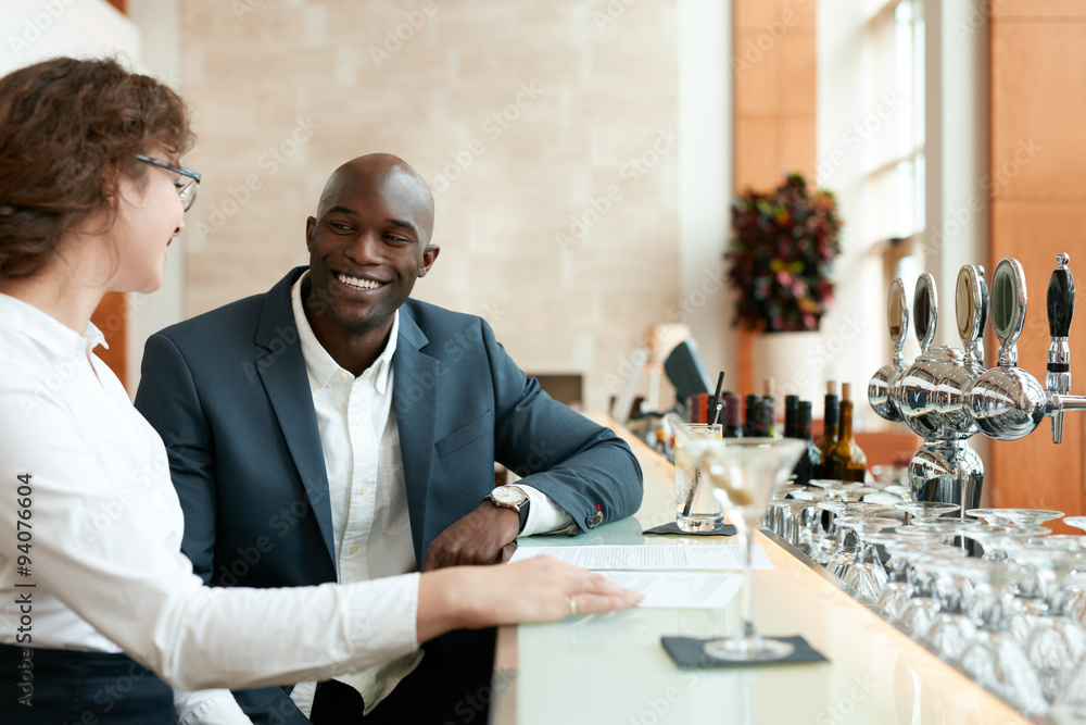 Young businessman sitting with woman at bar counter