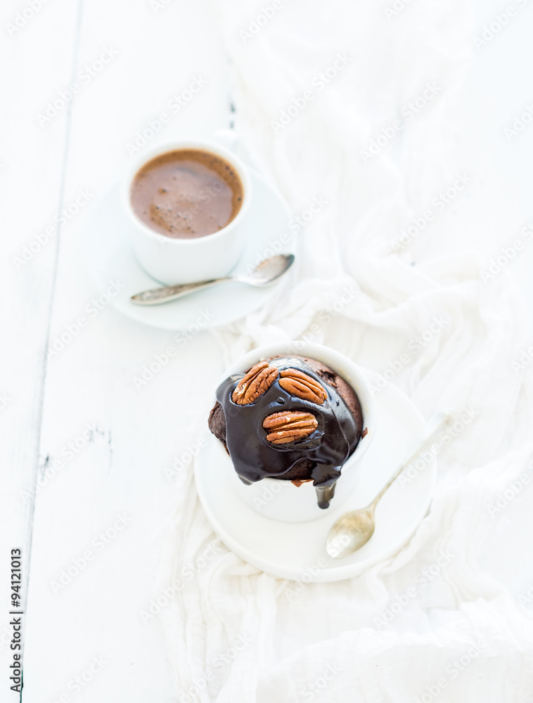 Tasty homemade brown muffin with chocolate ganache icing, pecan