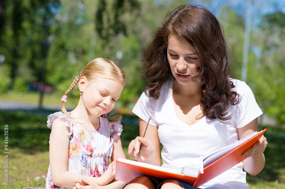 girl and a young woman reading a book together