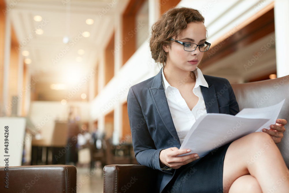 Businesswoman at lobby reading documents