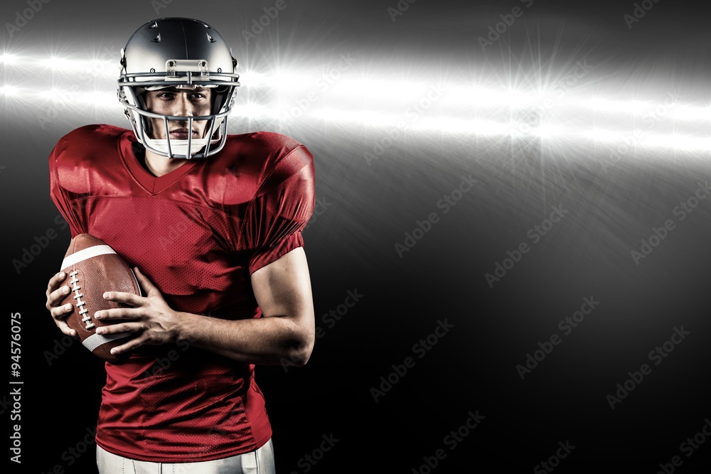 Composite image of american football player holding ball