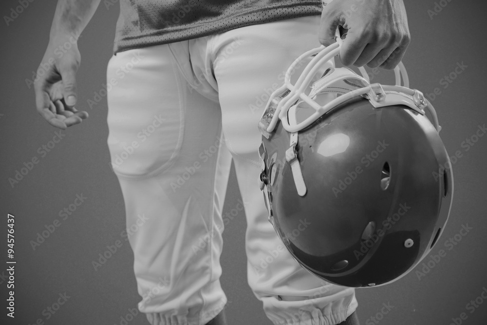 Composite image of an american football player holding helmet