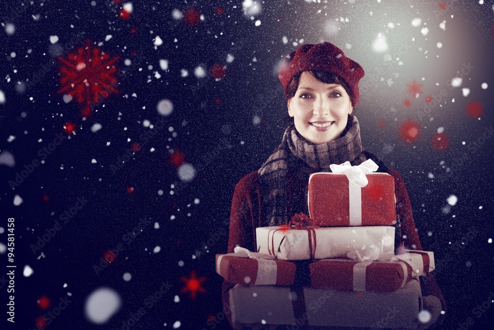 Composite image of smiling woman holding large presents